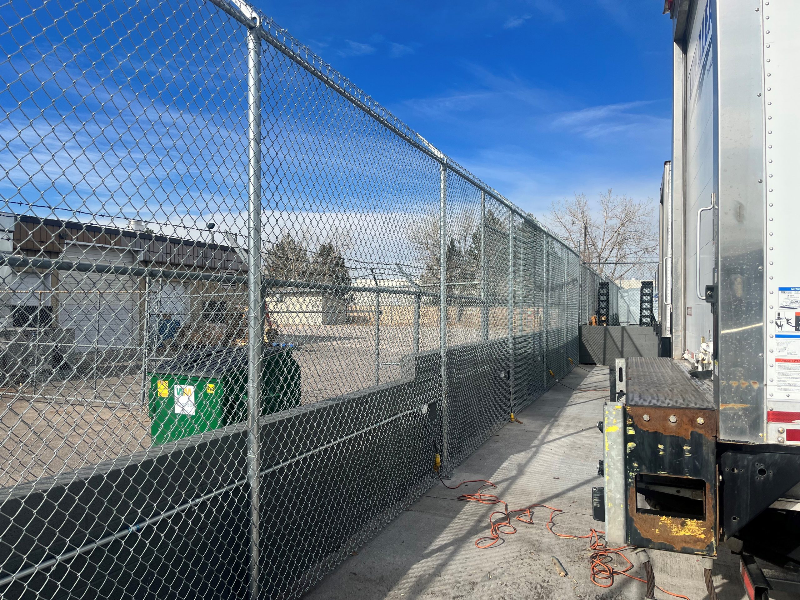 chain link commercial fence with box trucks