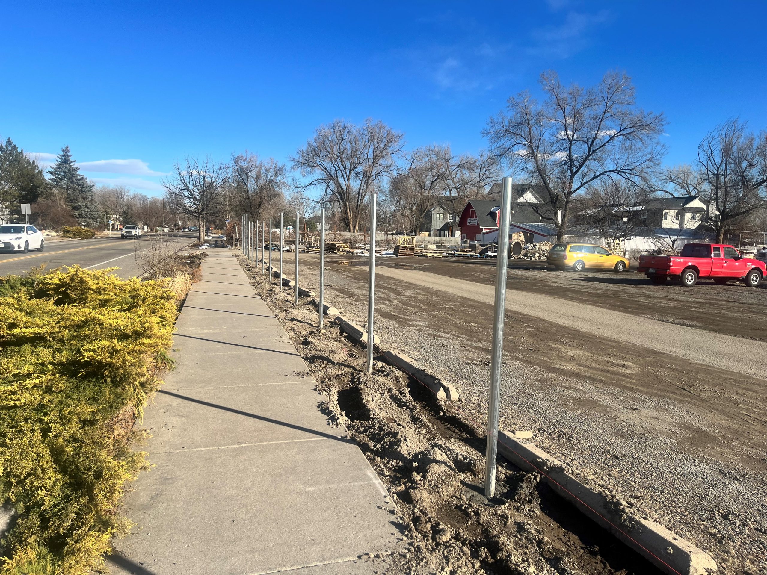 Commercial chain link fence surrounding industrial lot with trucks in Denver