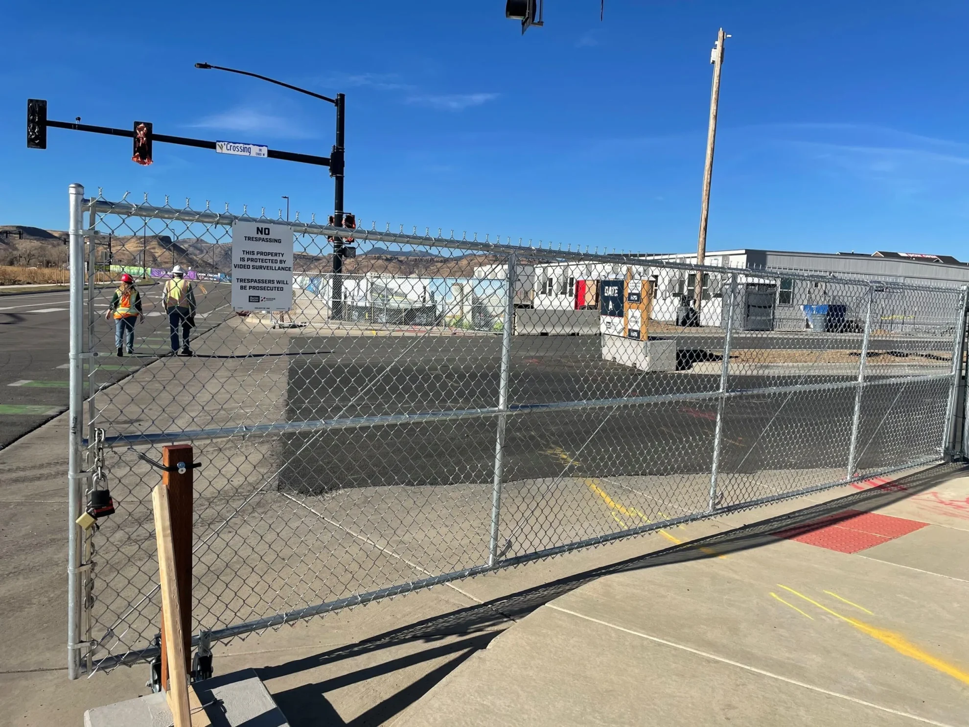 Commercial chain link fence installation with Denver workers on site