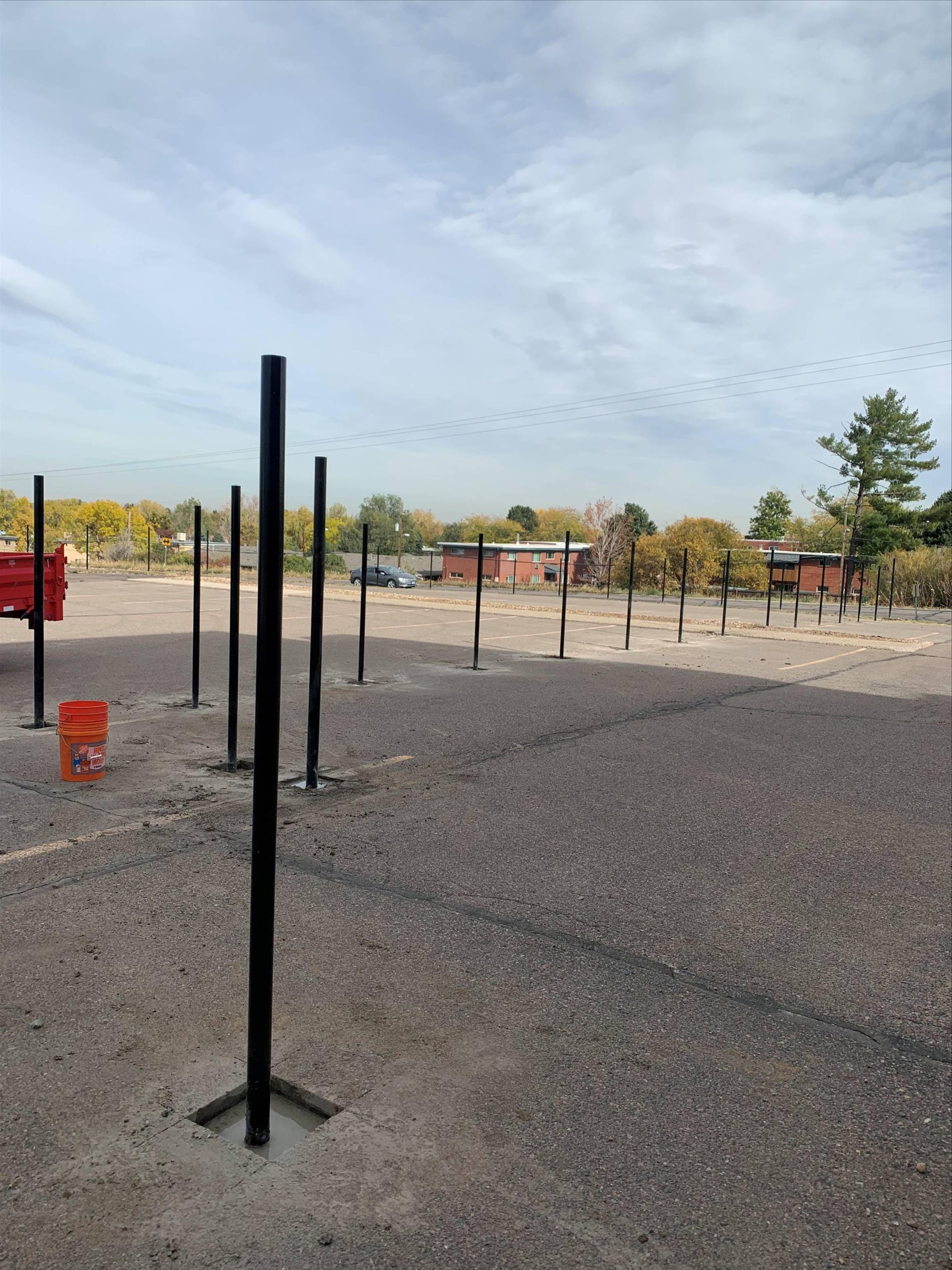 Fence crew installing commercial fence posts along property line in Denver