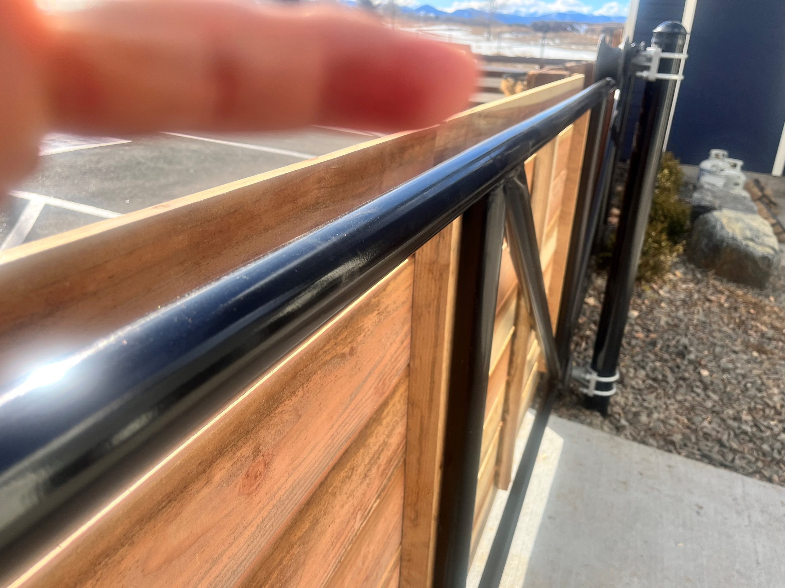 Repaired commercial sliding gate with wood infill and steel frame at a Denver property