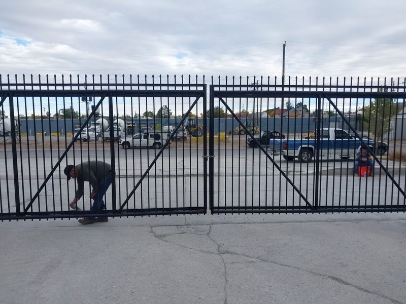Custom fabricated steel gate system being installed for a commercial property in Denver
