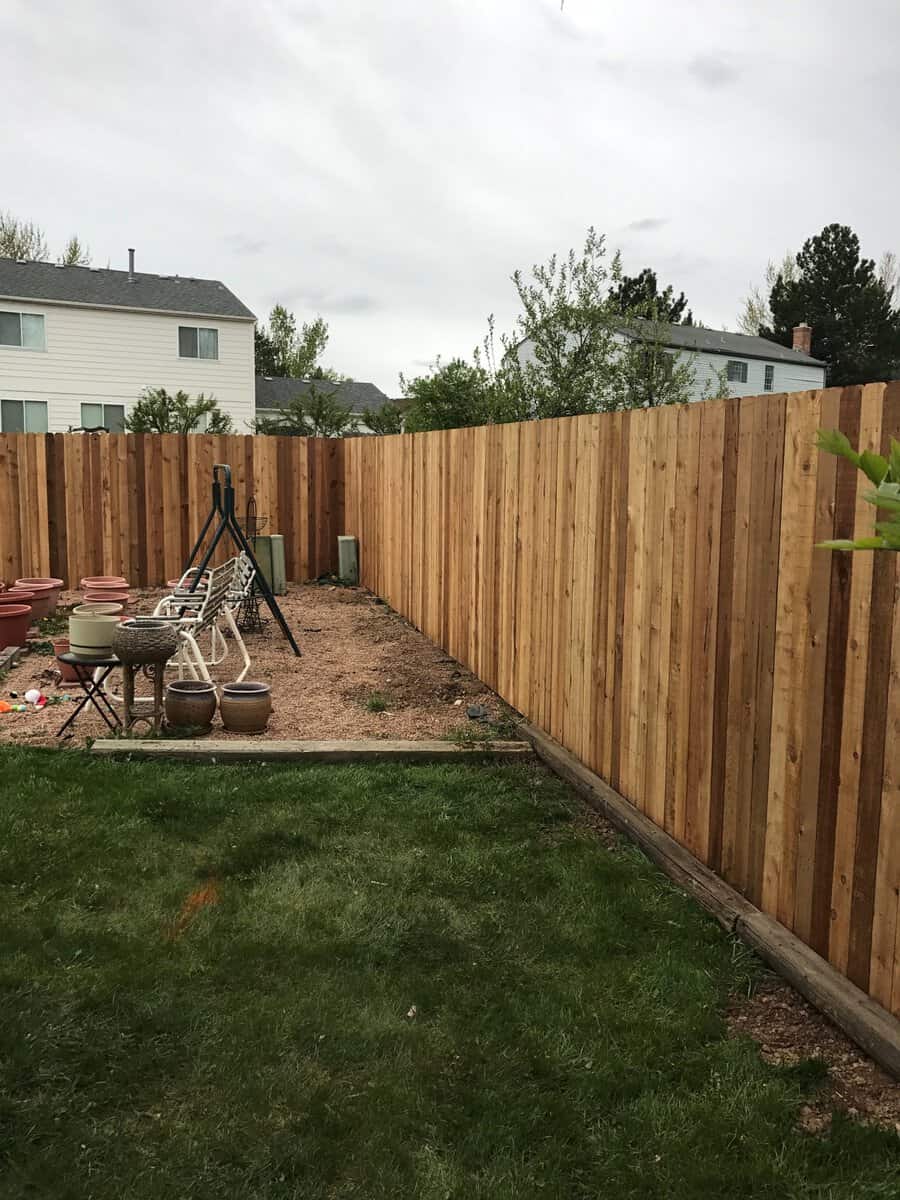 Denver Fence Company crew member installing residential fence panel