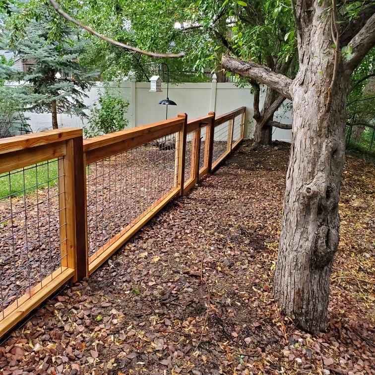 Wood and wire residential fence installed in a landscaped Denver backyard