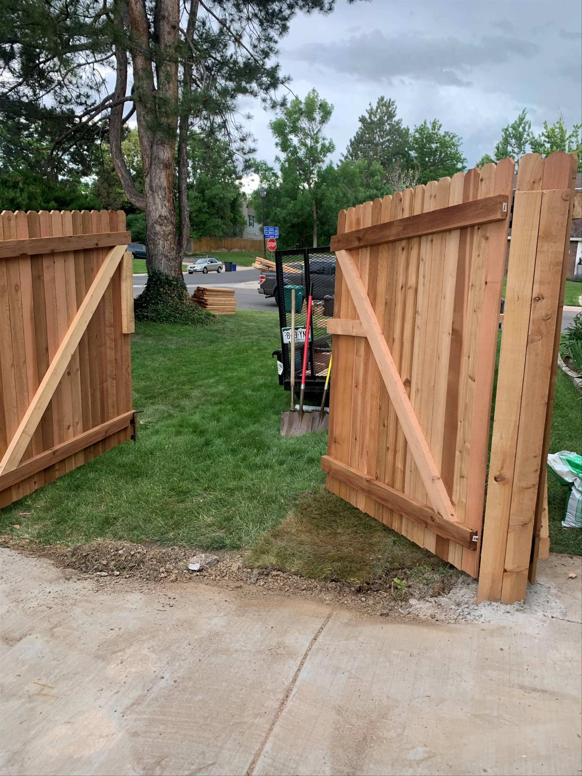 Double swing wood fence gate open in Denver residential yard