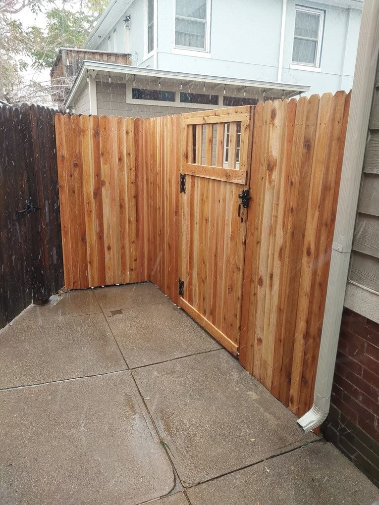 Repaired wood fence gate with new hinges and alignment correction in Denver