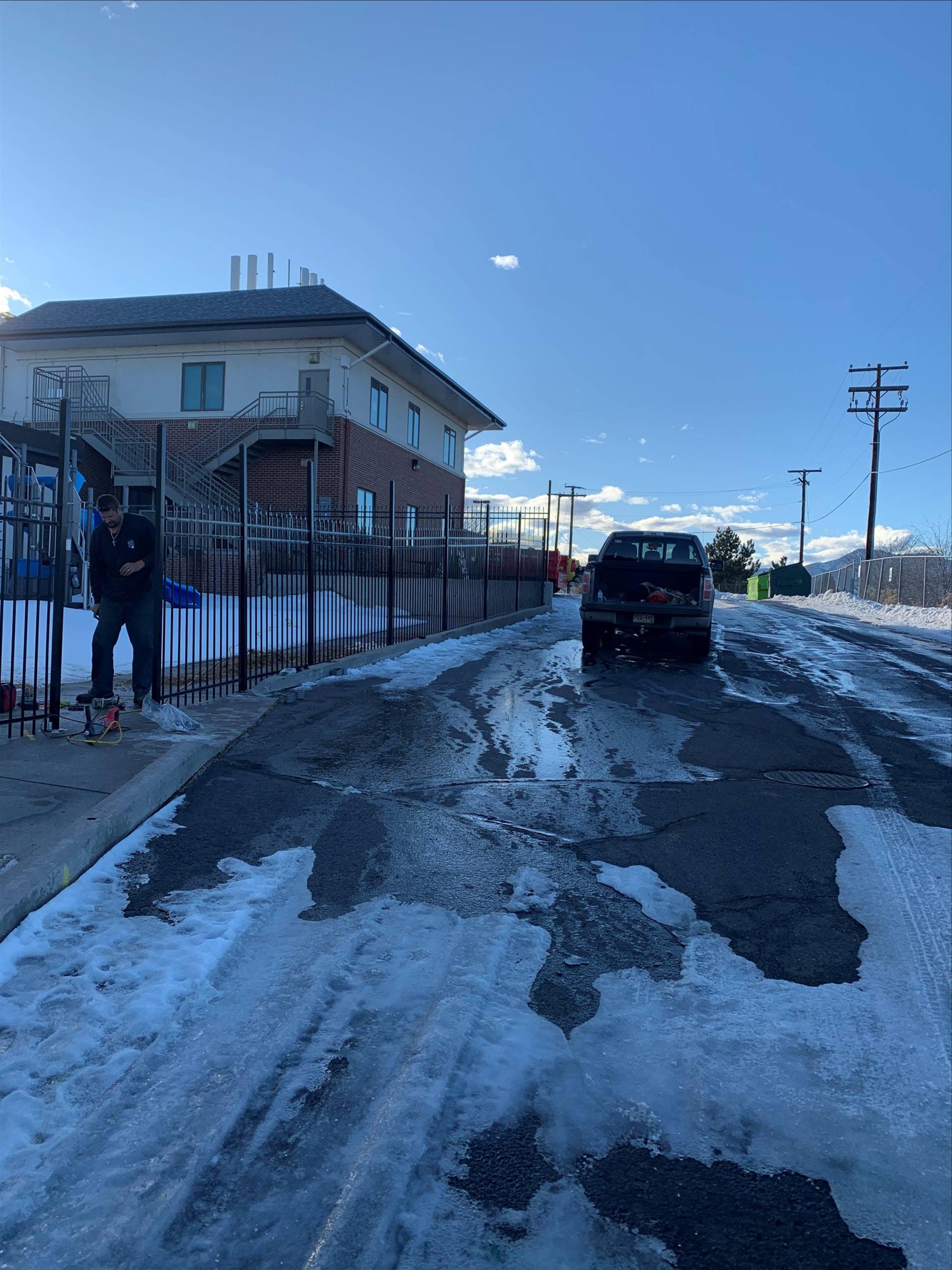 Metal fence installation crew working on a Denver area property in winter conditions