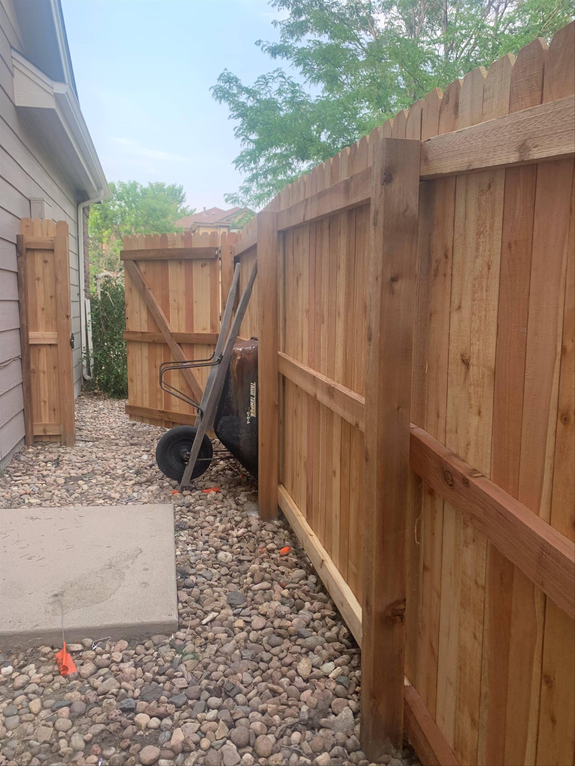 Residential fence gate installation in Denver backyard with wood privacy fence