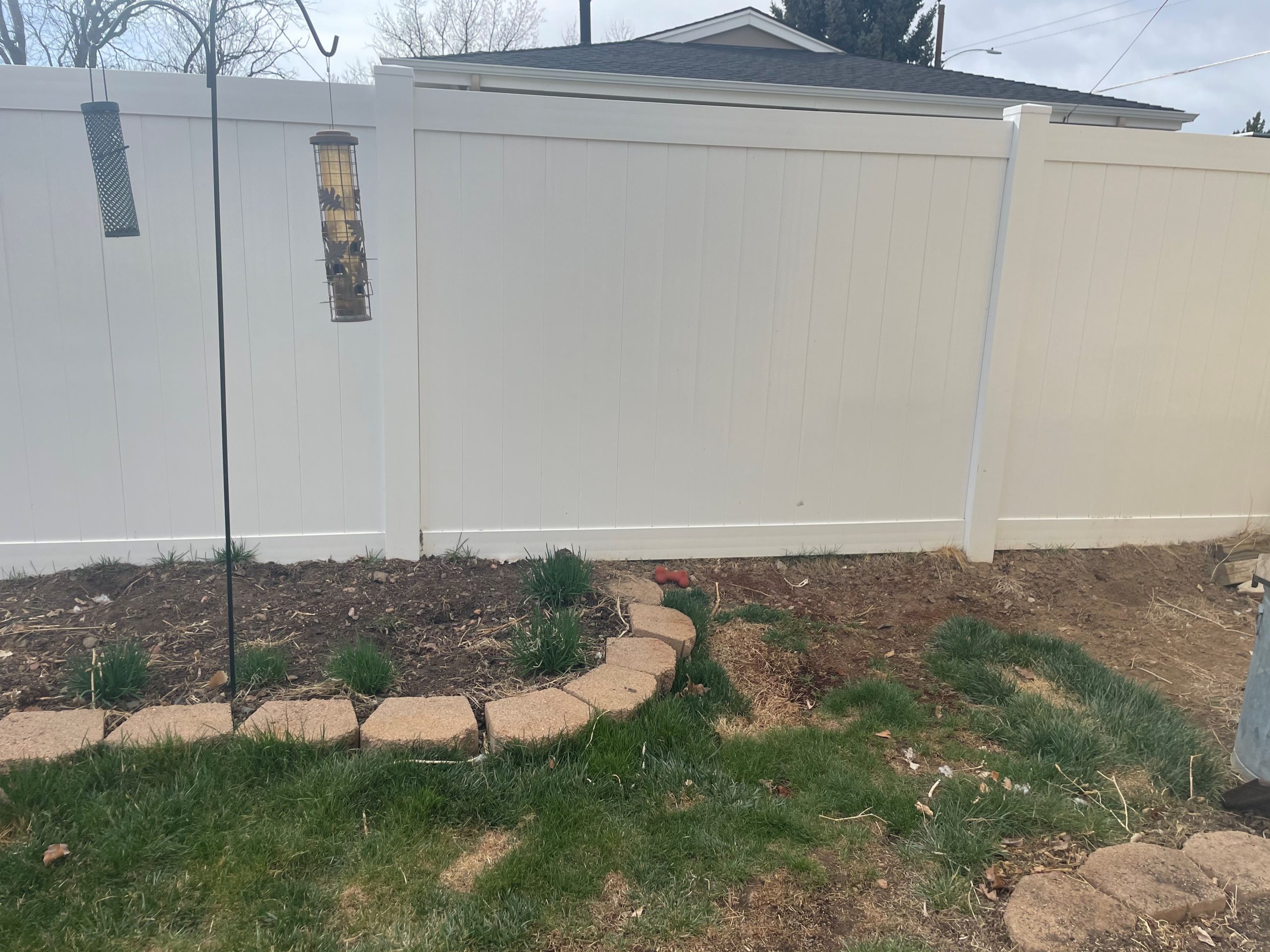 White vinyl privacy fence installed in a residential backyard in the Denver area
